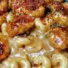 Plate of sweet and spicy honey pepper chicken served with creamy macaroni cheese.