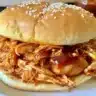 Delicious pulled Crockpot BBQ Chicken served with coleslaw and bread.