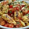 Delicious bruschetta chicken pasta topped with fresh basil and tomatoes