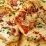 Plate of creamy Garlic Parmesan Chicken garnished with herbs