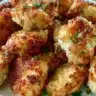 Crispy garlic parmesan chicken bites cooked in an air fryer, garnished with herbs.